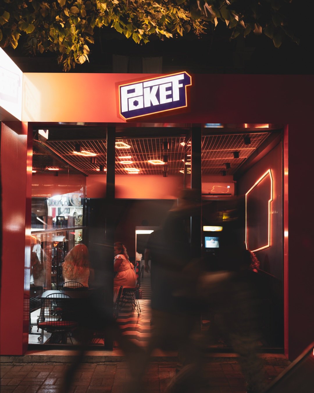 The illuminated POKET entrance photographed at night.